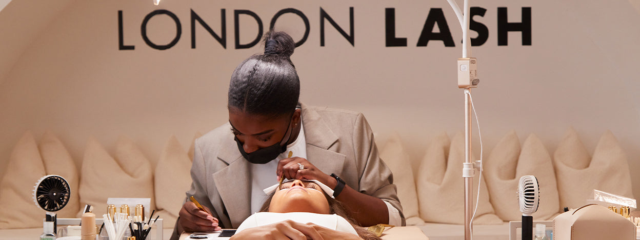 lash trainer brushing a clients lashes 