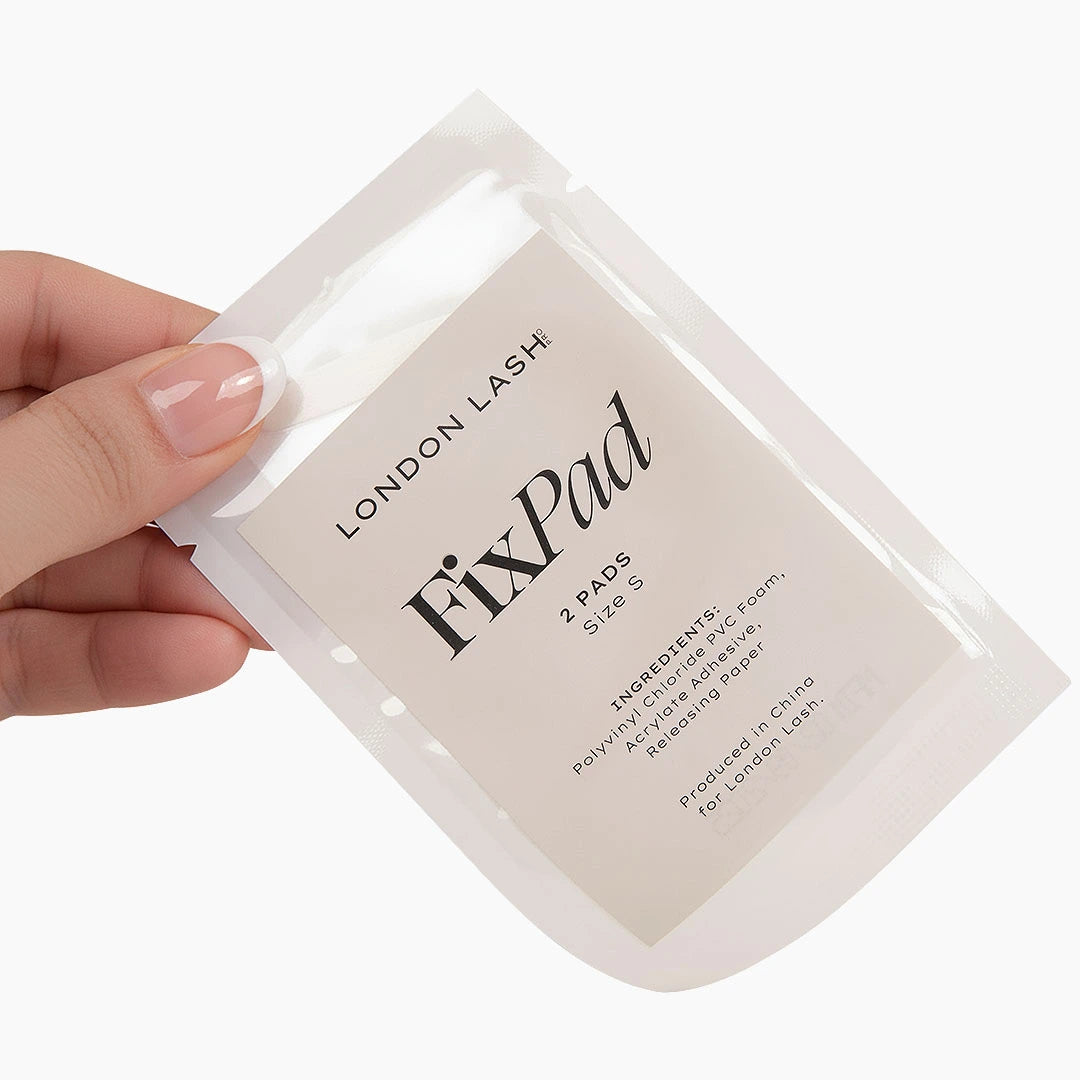 Hand holding London Lash Fix Pads against a white background