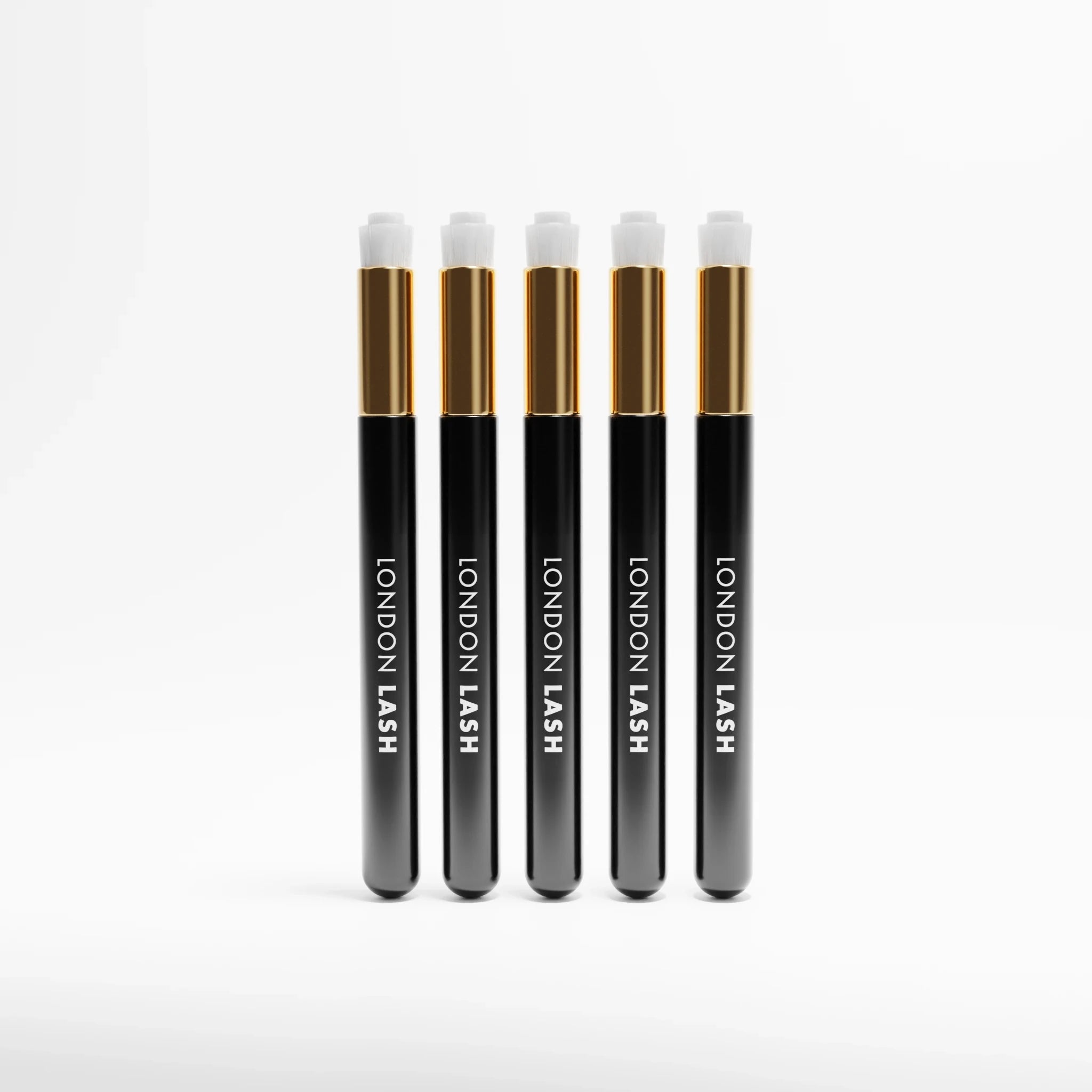 Five black and gold Lash & Brow Cleansing Brush labeled 'London Lash' on a white background