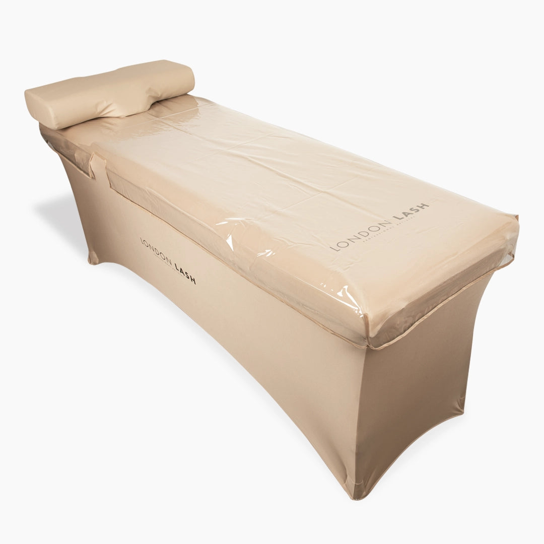 Beige massage table protected by 'London Lash' Clear Beauty Bed Cover