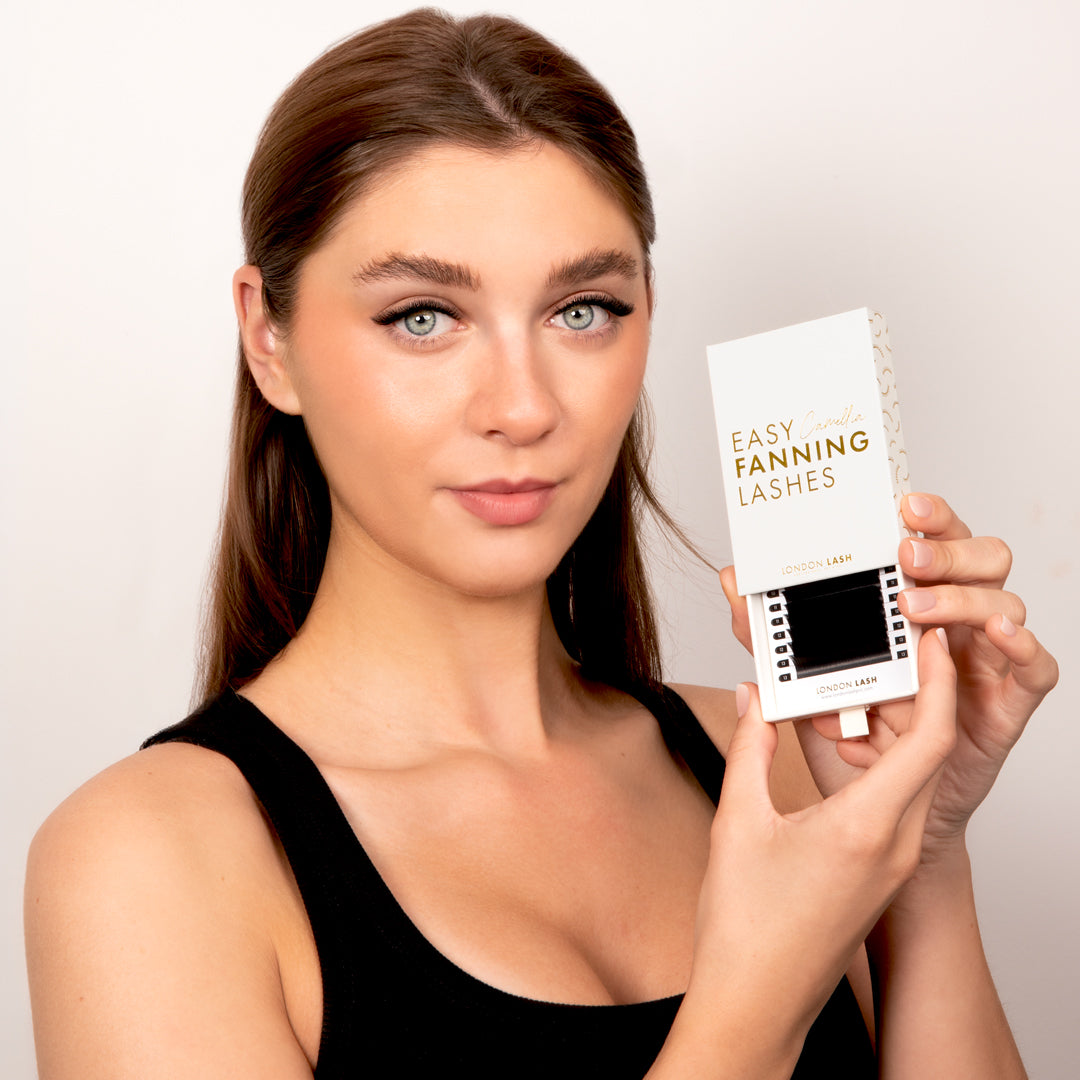 Model wearing Camellia Easy Fanning Volume Lashes 0.07 and holding lash tray box