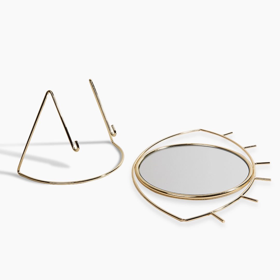 London Lash mirror with eye-shaped gold frame on a white background