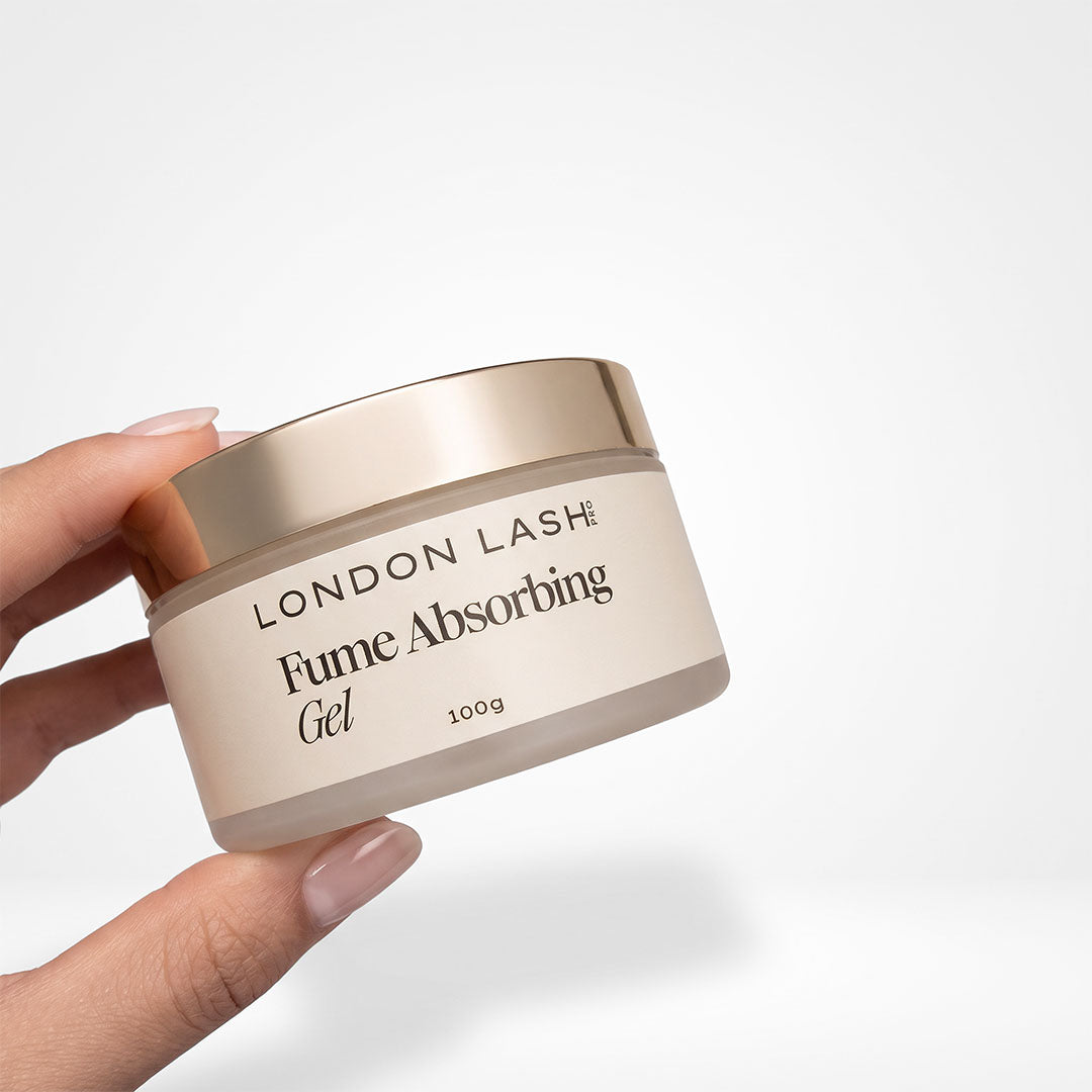 A hand holding a jar of London Lash Fume Absorbing Gel against a clean white background.