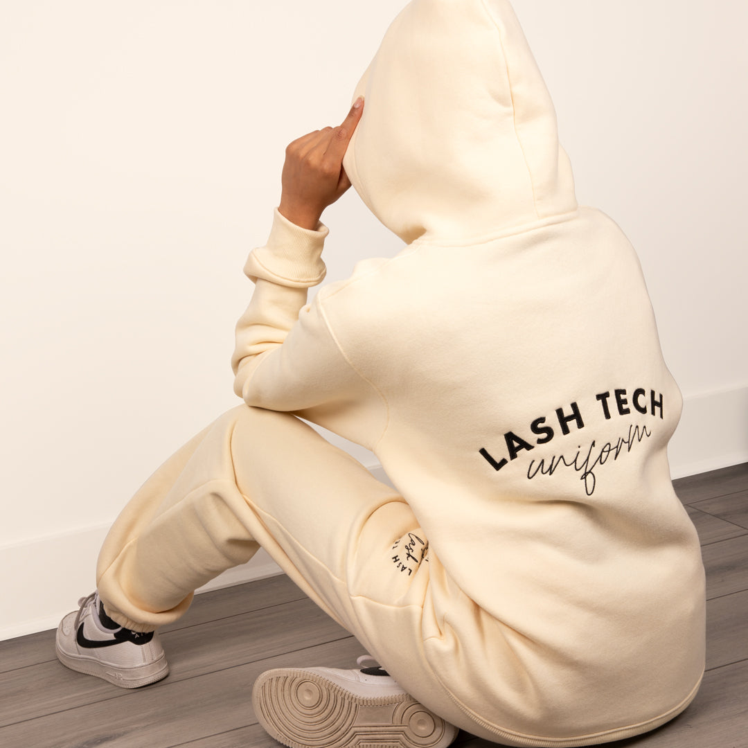 Lash technician wearing a lash tech hoodie and sweatpants