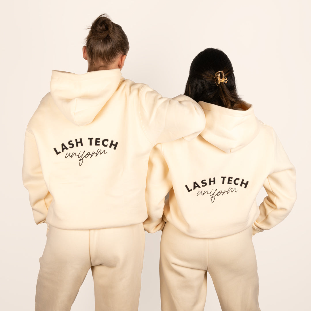 Two lash technicians wearing London Lash beige hoodie and sweatpants 