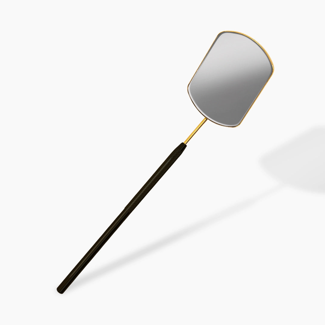 lash mirror with black handle and gold rim on a white background