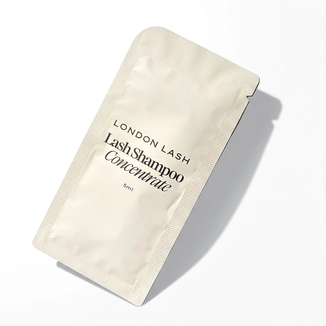 A single-use beige foil packet of London Lash Lash Shampoo Concentrate, 5ml, displayed diagonally on a clean white background with a soft shadow.