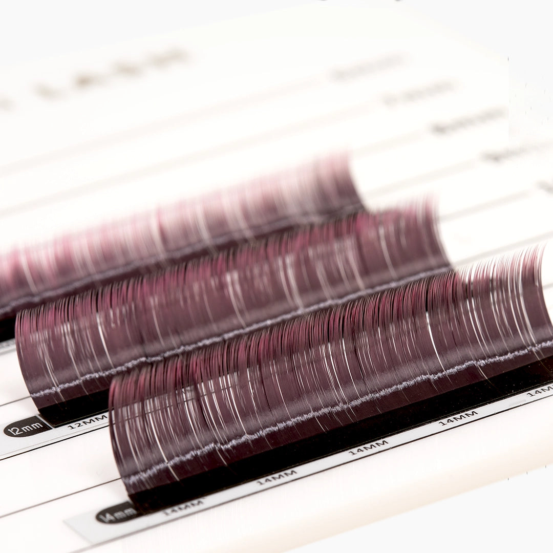 Three strips of pink ombre eyelash extensions on a palette