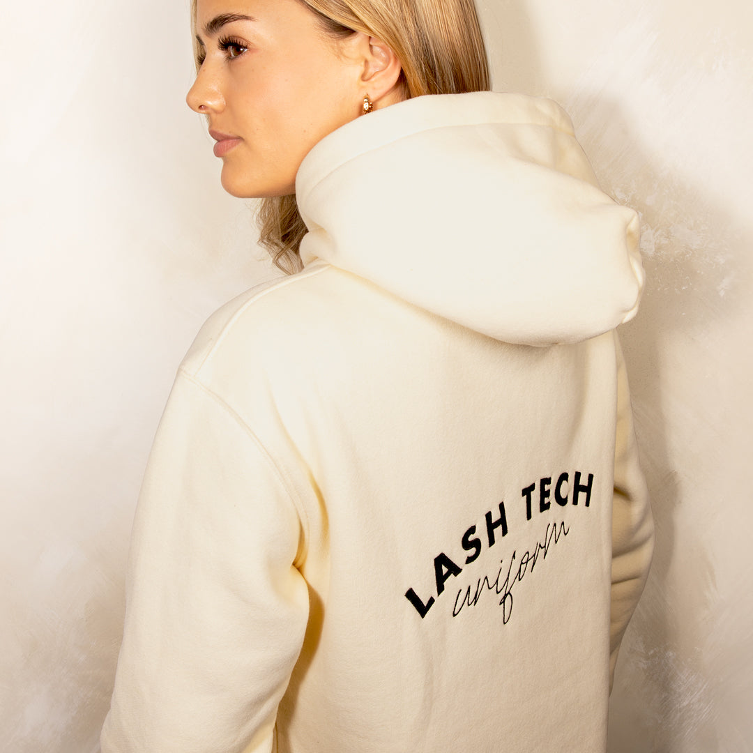 Lash technician showing the back of her lash tech hoodie