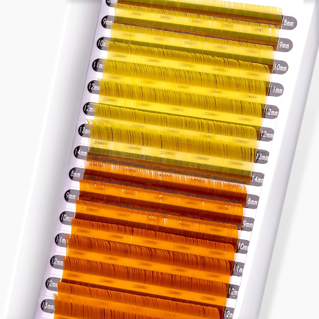 Close up of London Lash yellow and orange faux mink coloured lash extension strip and curls on white background