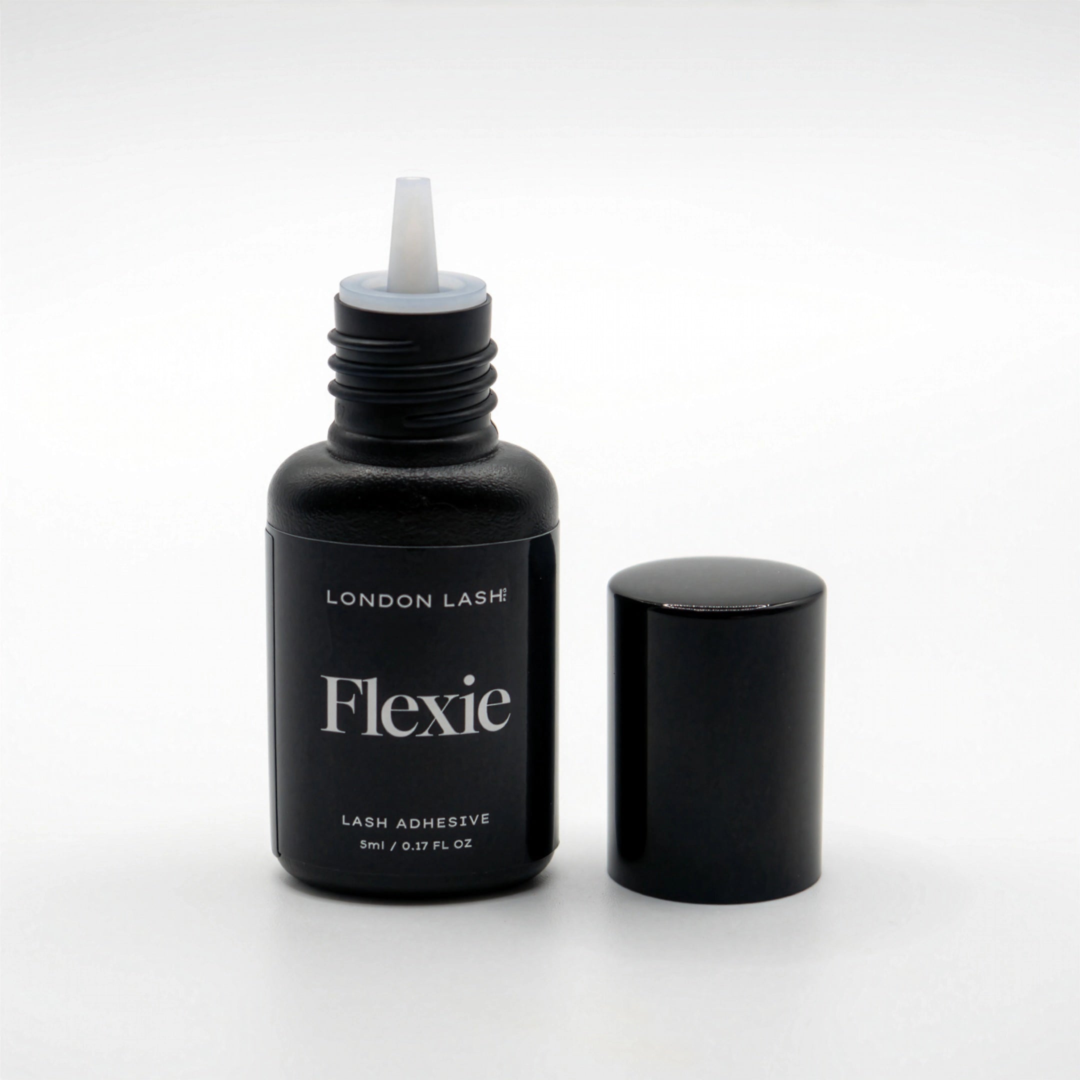 Opened bottle of London Lash Flexie lash adhesive on a white background