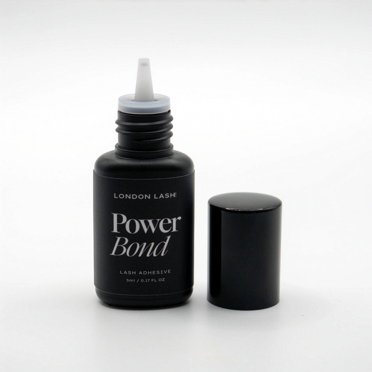 Opened bottle of London Lash Power Bond lash adhesive on a white background