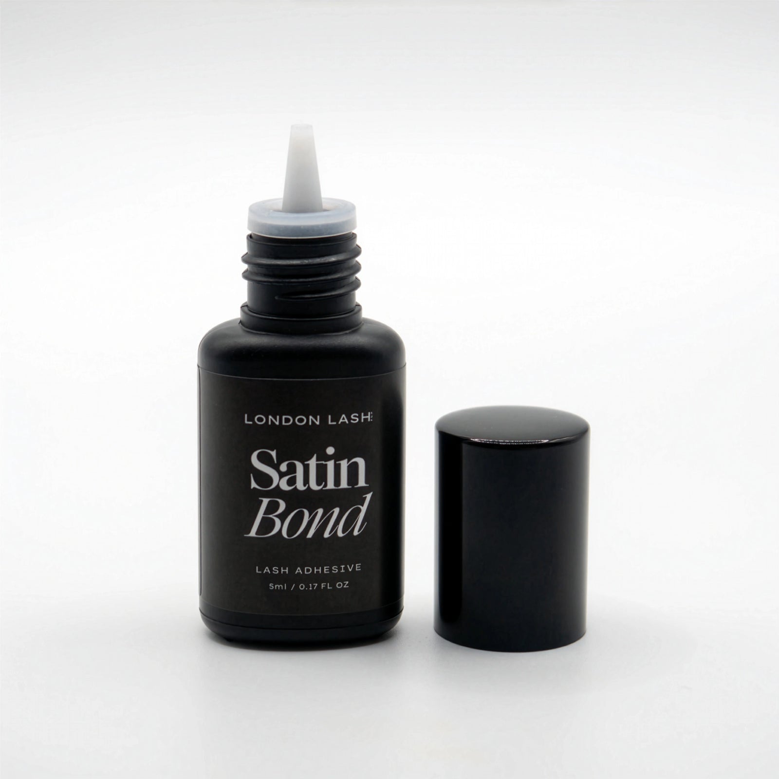 Opened bottle of London Lash Satin Bond lash adhesive on a white background